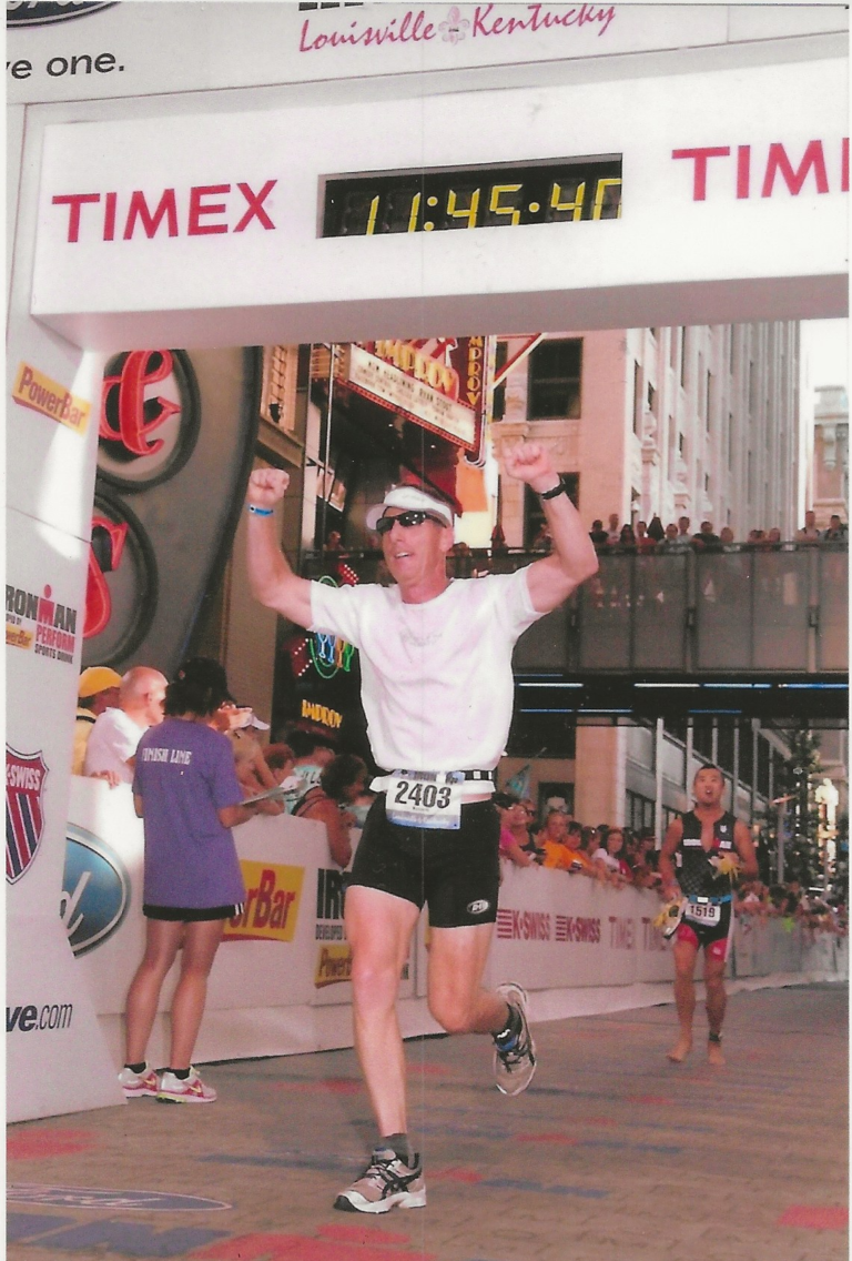 Ken Downer, author of Self-Coached to Kona, crossing the finish line of his first full Ironman race in Louisville, Kentucky, in 2011