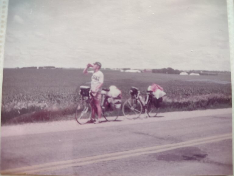 Ken Downer, author of Self-Coached to Kona, pauses for a water break in Iowa during his 64-day bicycle ride across the United States.